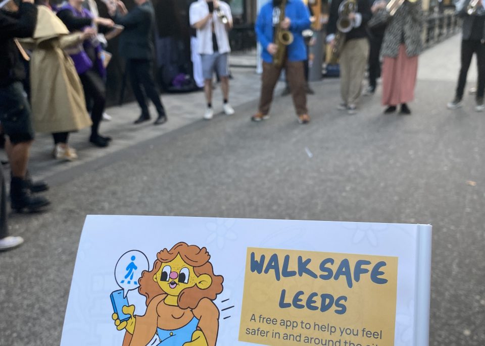 Walksafe sign in front of the brass band performing at the parade to celebrate te launch