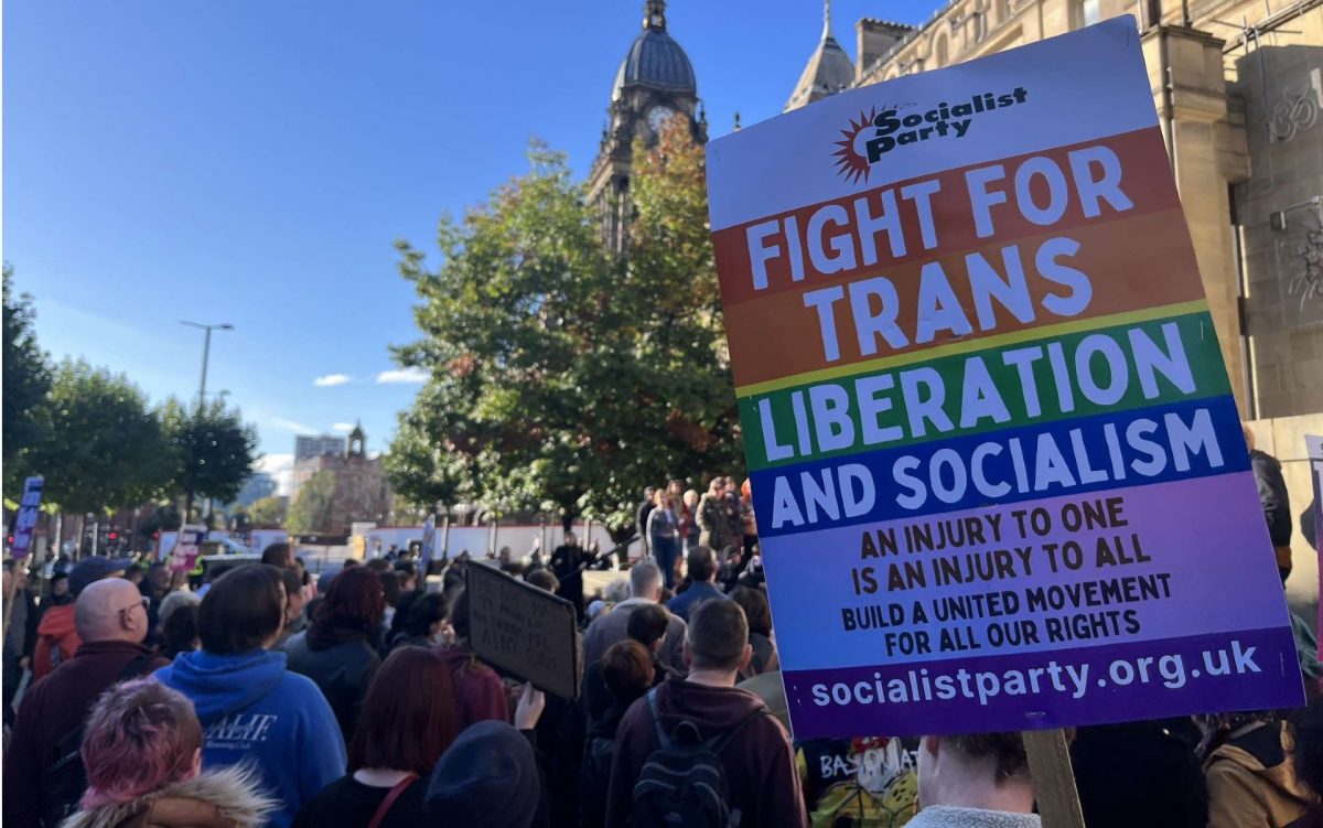 protesters holding up signs at trans rights protest