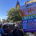 protesters holding up signs at trans rights protest