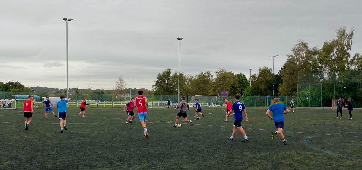 Football training session, player kicking the ball to his team mate