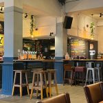 Empty pub with barstools and bar in background