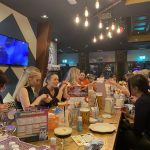 group of women sat at a table painting pottery