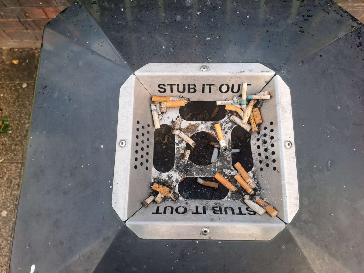 A half-full ash tray on top of a bin