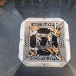 A half-full ash tray on top of a bin