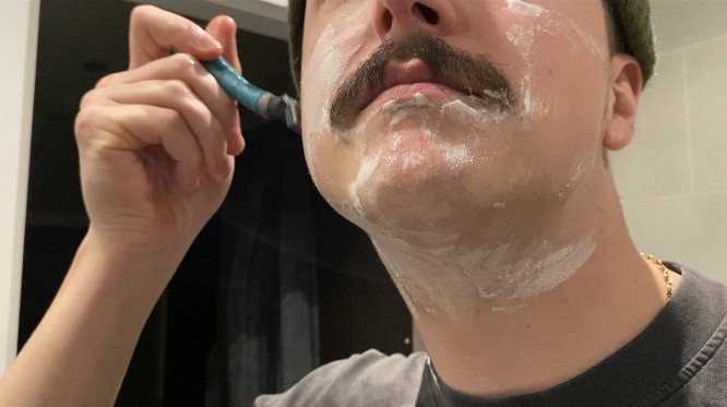 man shaving around moustache