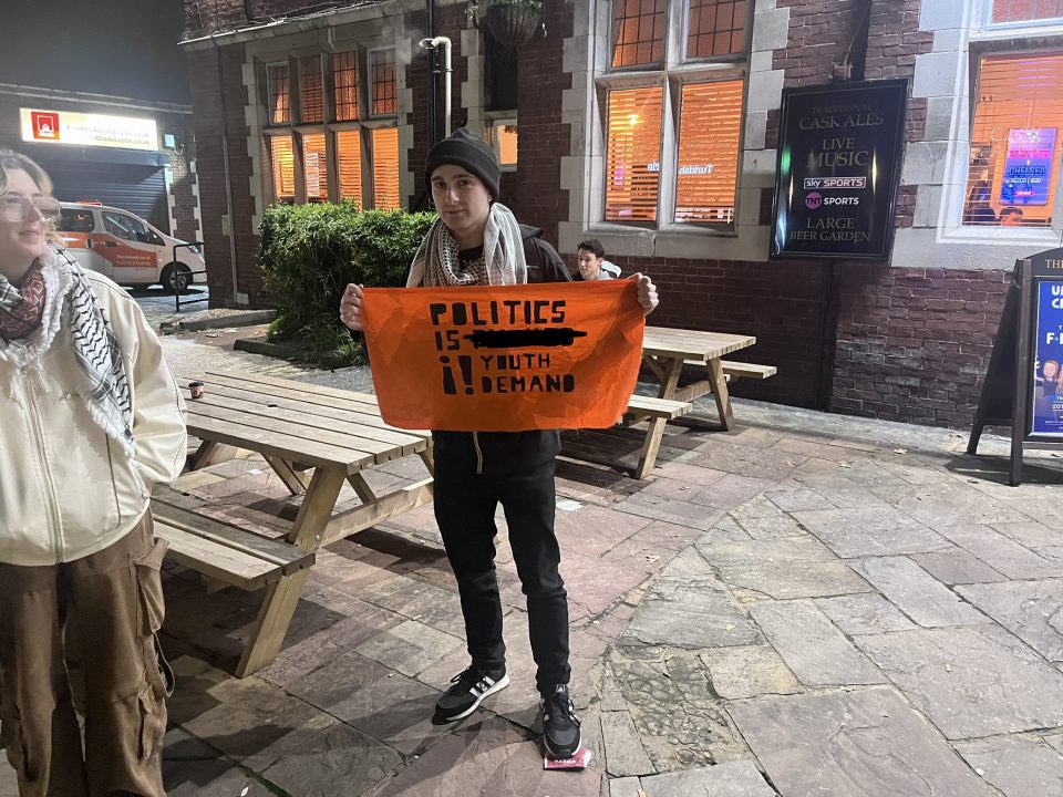 Picture of Youth Demand member holding sign