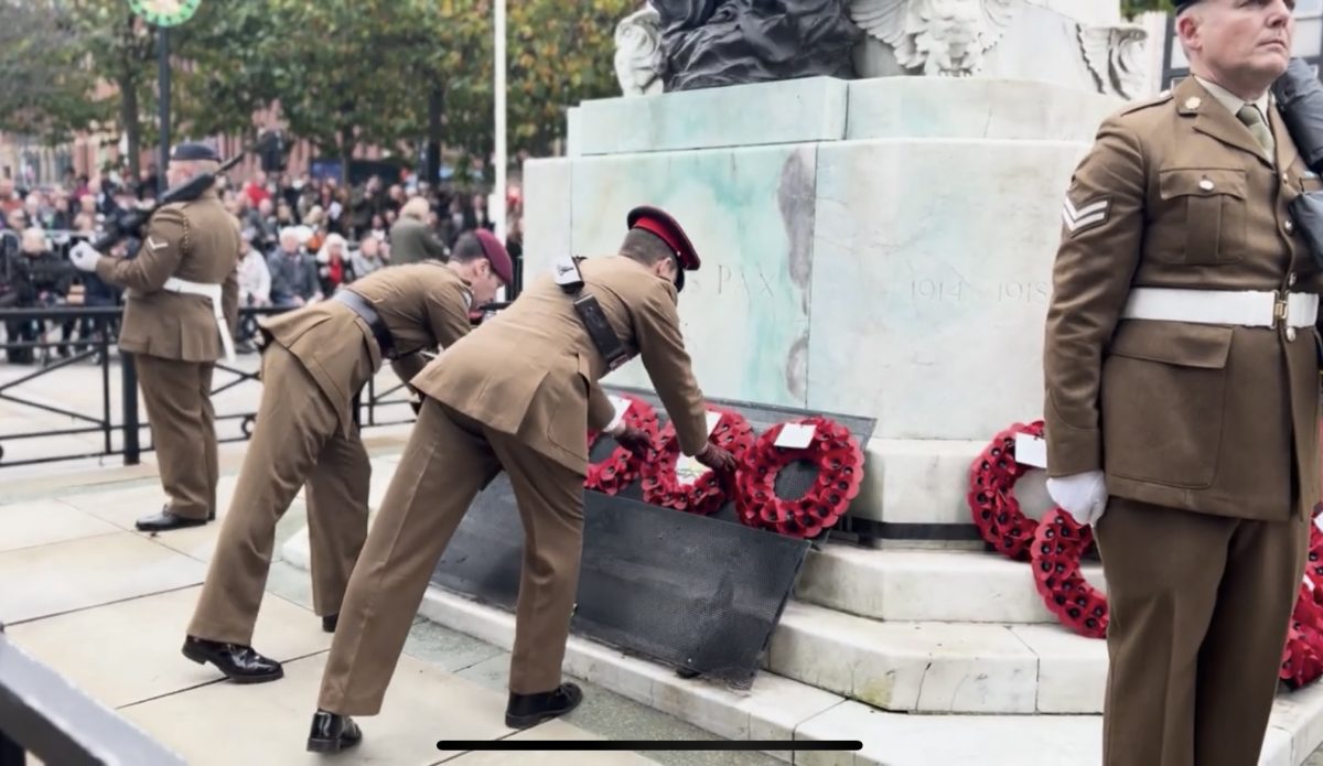 Two army men in uniform are laying wreaths at Leeds cenotaph on Remebrance Sunday