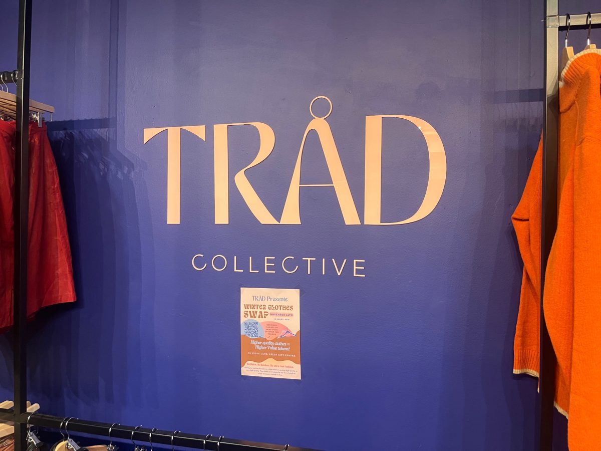 A purple wall has the name TRAD Collective dispolayyed across is.