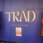 A purple wall has the name TRAD Collective dispolayyed across is.