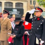 In this image the Lord Lieutenant is saluting to the war memorial in Victoria Gardens as people look on