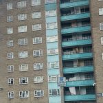 A large block of brown flats with blue balconies.