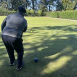 A man Bowling a ball on a field.