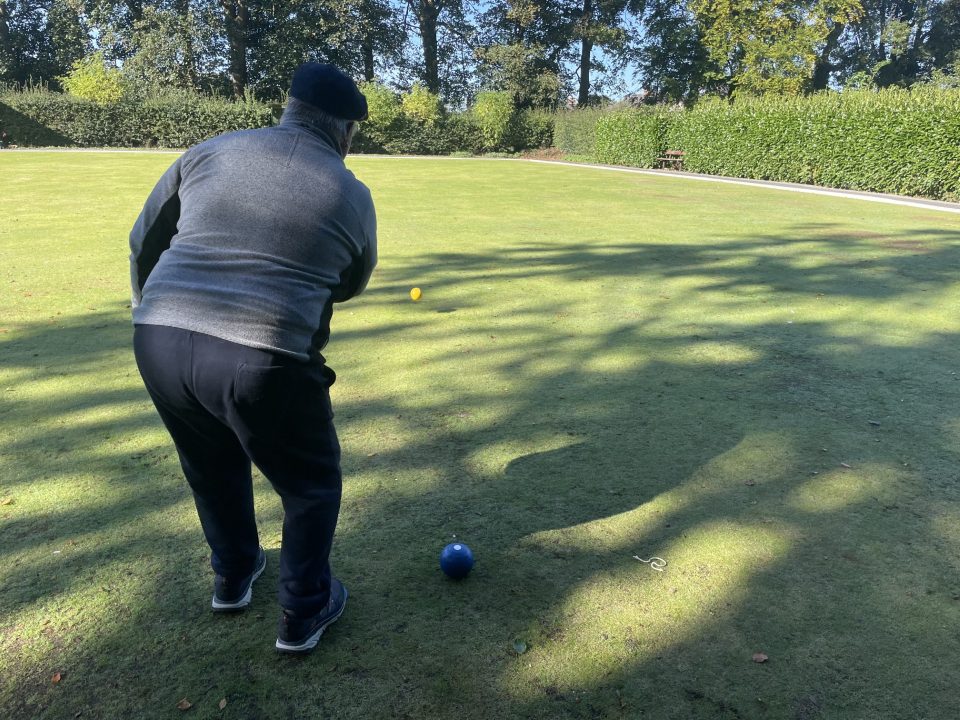 A man Bowling a ball on a field.