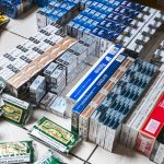 Boxes of cigarettes and packets of nicotine on a table as a result of the counterfeit goods raid