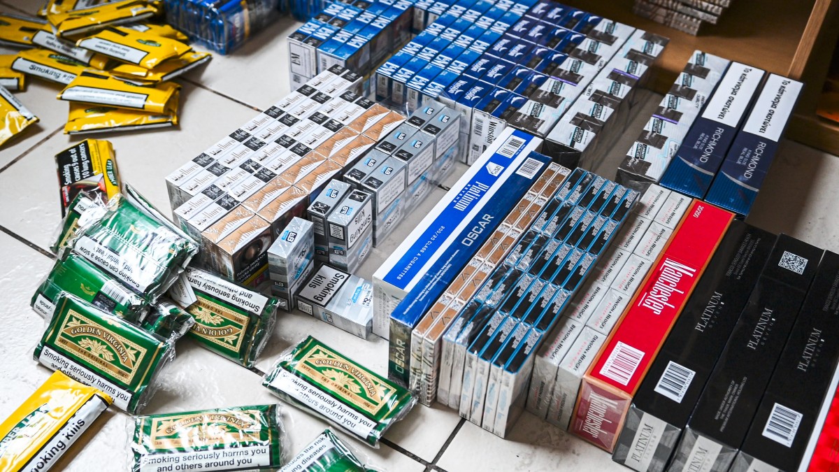 Boxes of cigarettes and packets of nicotine on a table as a result of the counterfeit goods raid