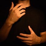 A man with his hands on his chest