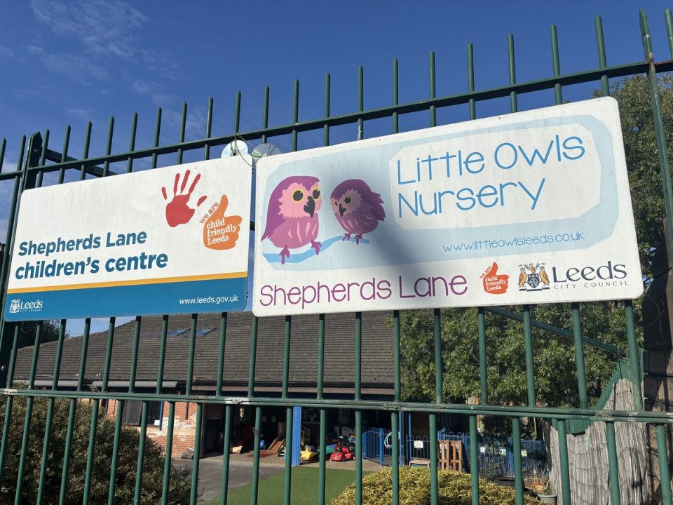 Signs for Little Owls Nursery placed on a fence outside of the nursery
