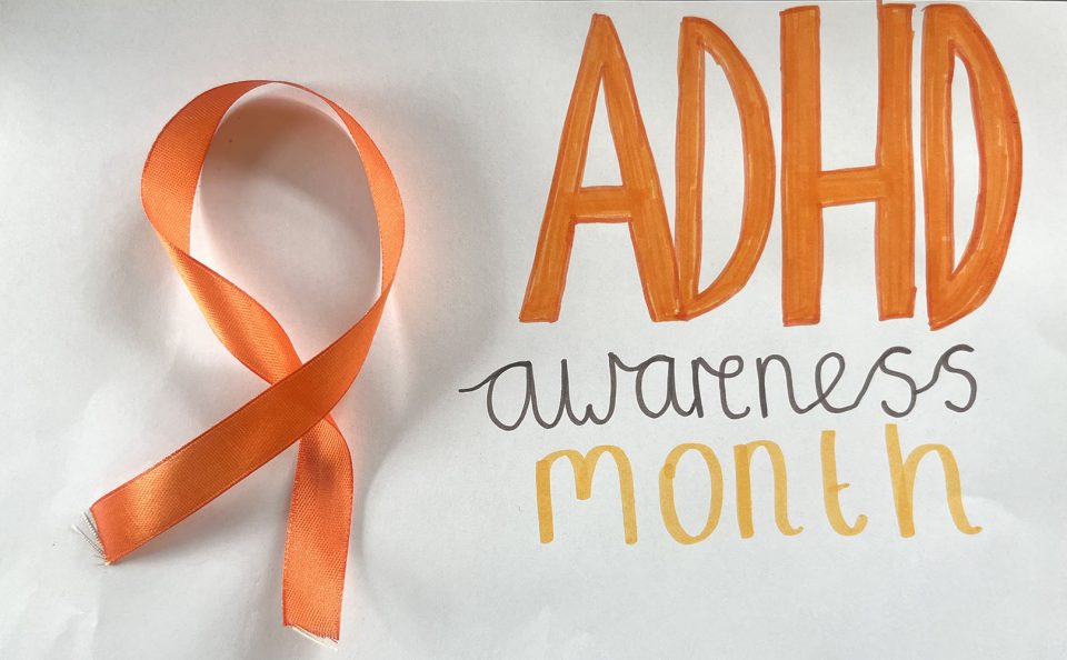 Orange ADHD awareness ribbon on the left; bold orange "ADHD" text with "awareness month" written below on the right.
