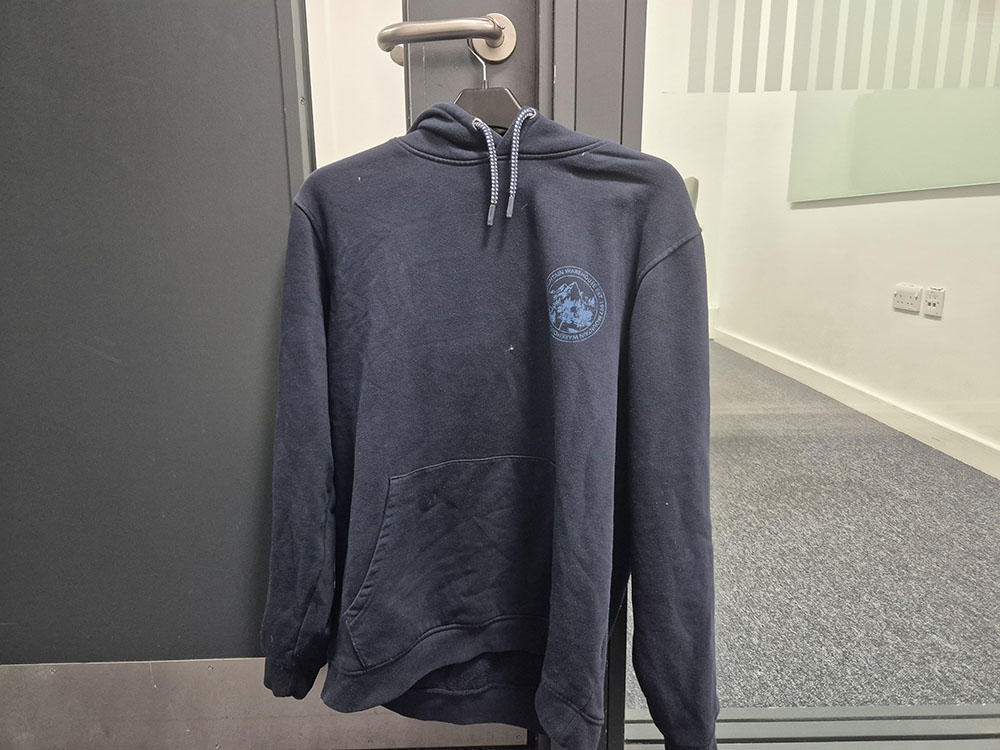 A recreation of shoplifting with a blue hoodie hanging on a door.