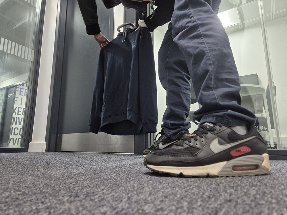 A recreation of shoplifting with shoplifter stealing a blue hoodie