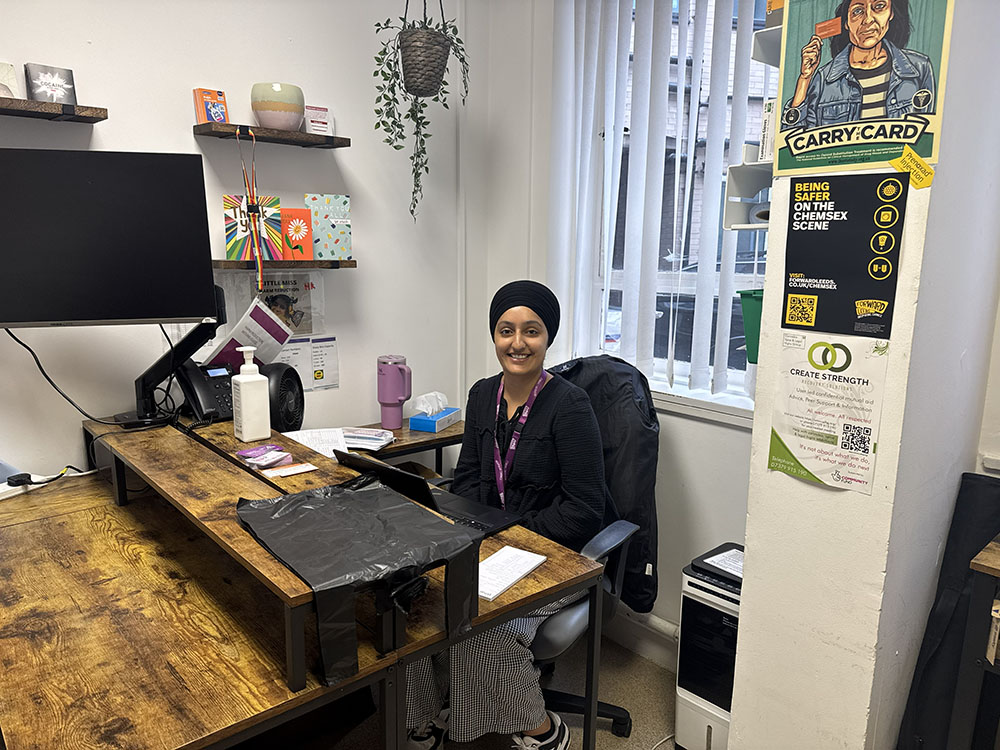 Woman sat at her desk, to provide harm reduction support.
