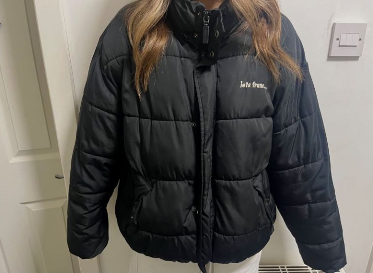 Black puffer jacket with white text on chest reading “lets frus...”.