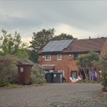 house with solar panels from view of driveway