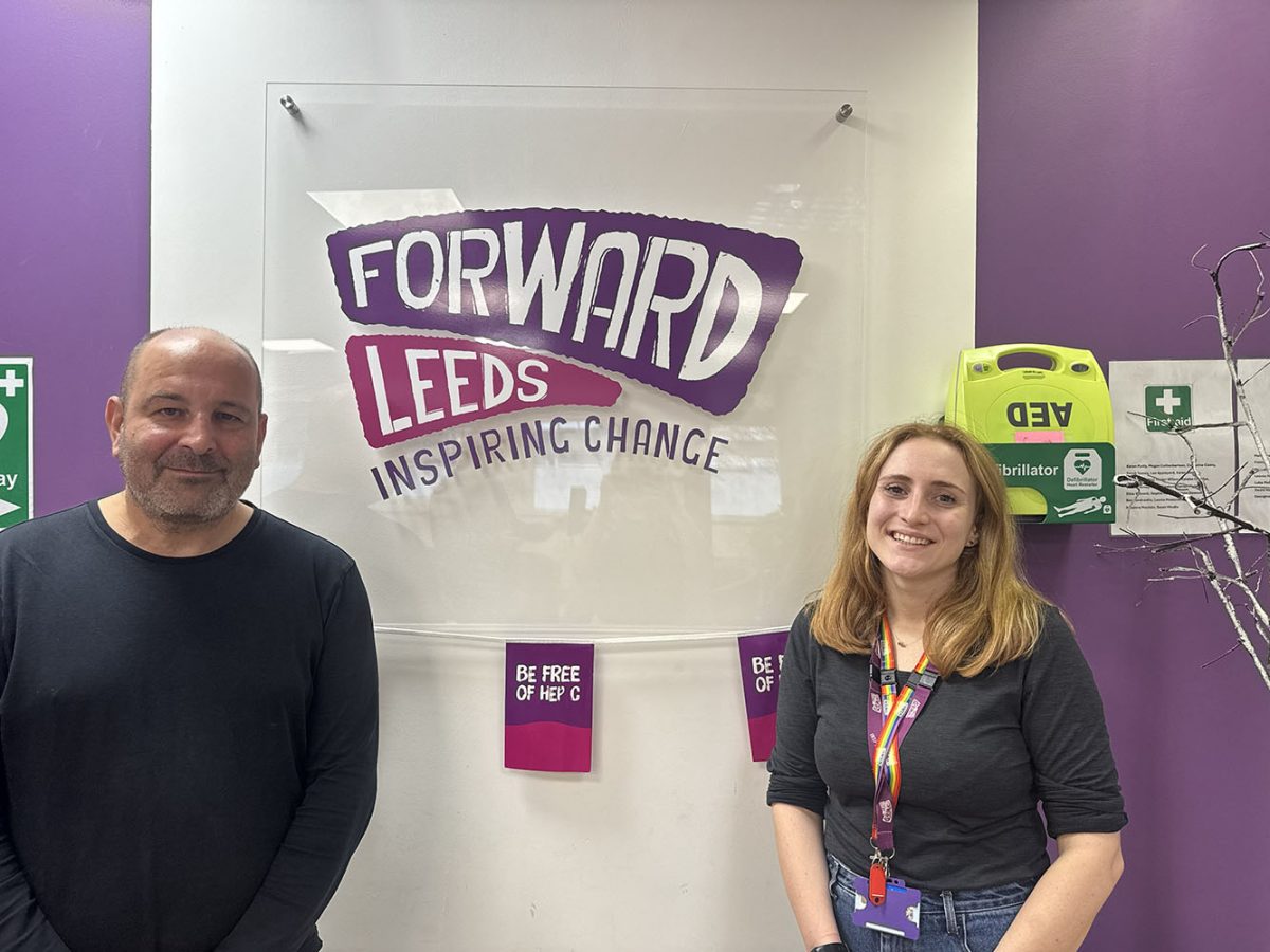 A man and a woman stood in front the 'Forward Leeds' sign.