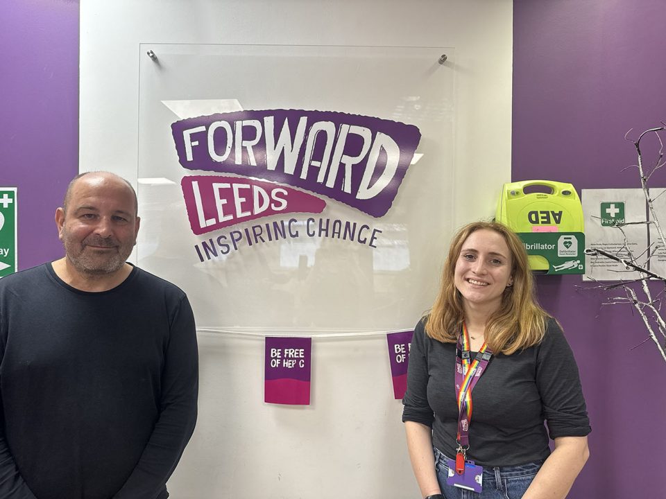 A man and a woman stood in front the 'Forward Leeds' sign.