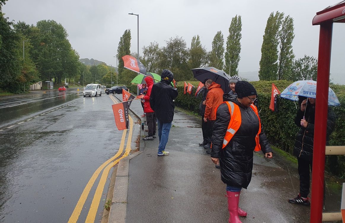 The image shows GMB Union members on the picket line on Skipton Road
