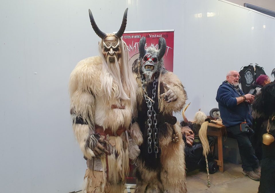The image shows two goth festival attendees dressed in scary costumes