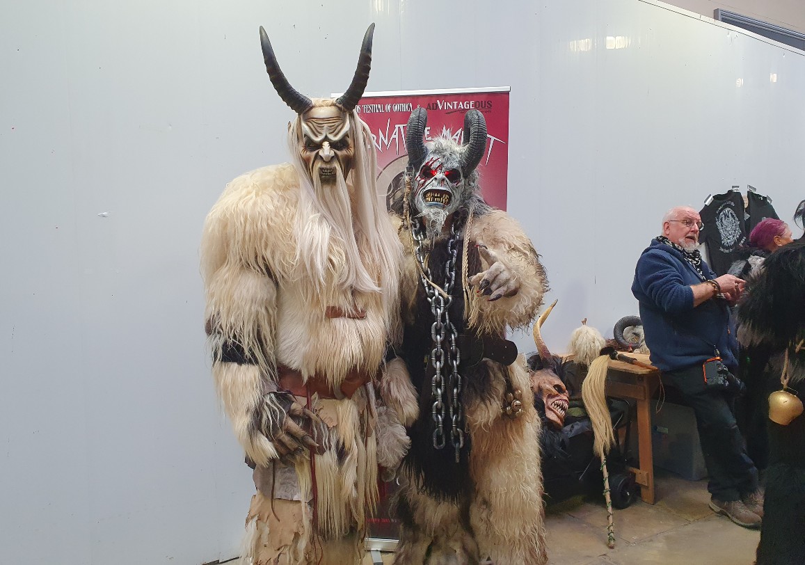 The image shows two goth festival attendees dressed in scary costumes