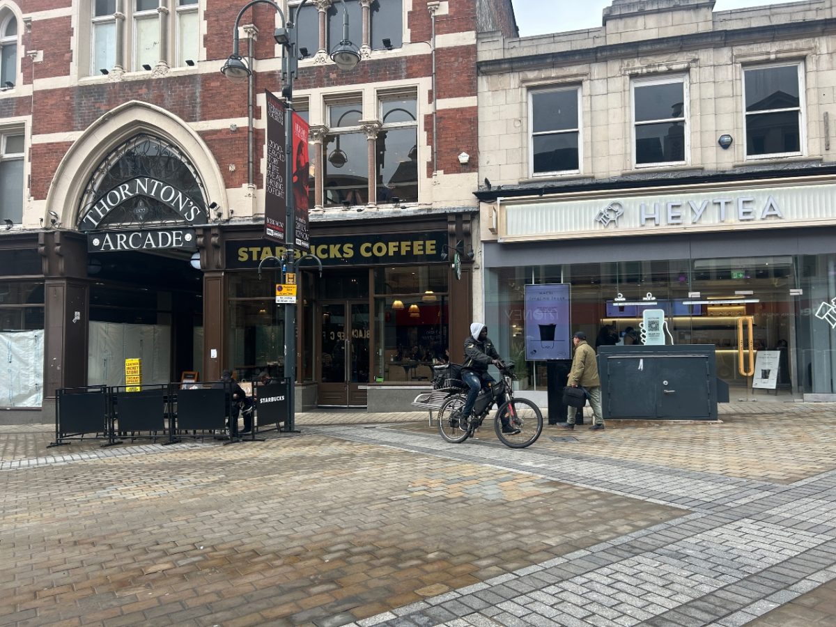 image of delivery driver on an e-bike outside of briggate high street in Leeds.