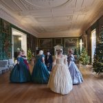 The image shows a group of dancers in historical attire at Temple Newsam
