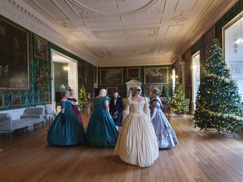 The image shows a group of dancers in historical attire at Temple Newsam