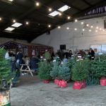 The image shows a farm with visitors and trees inside sat down