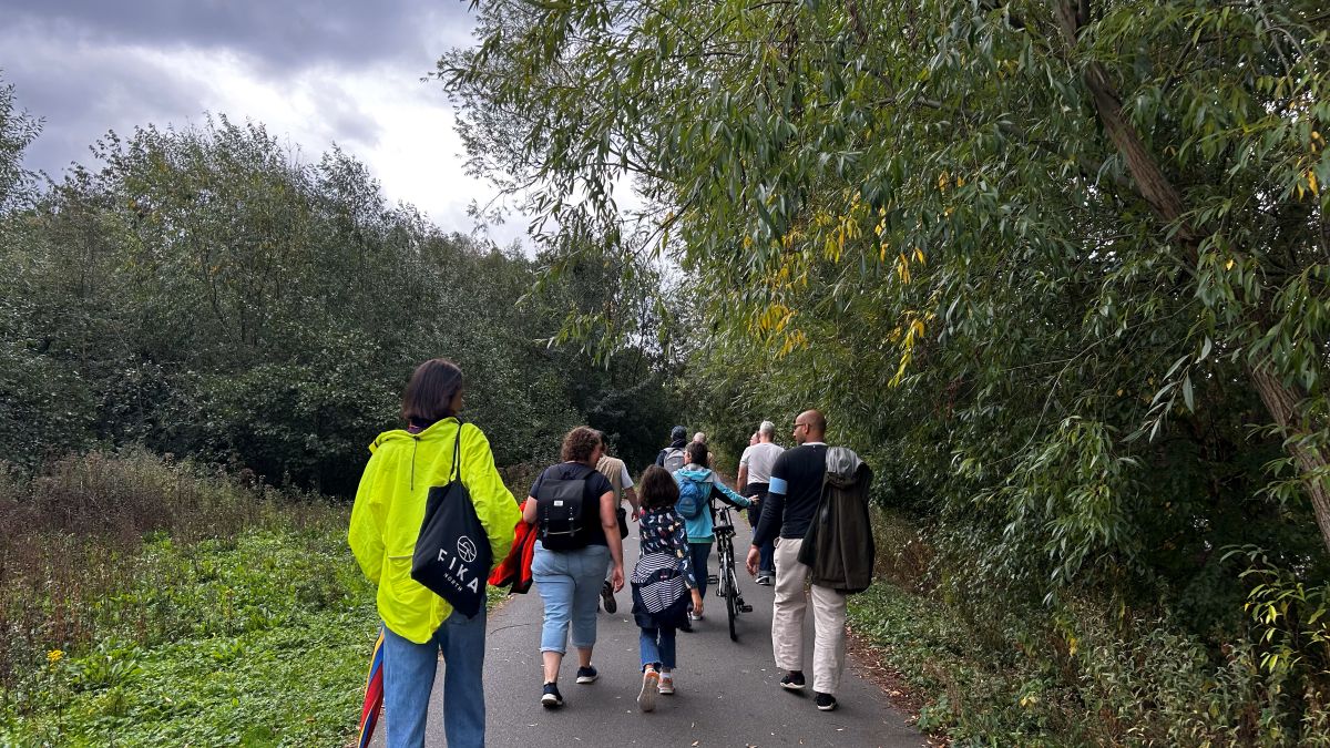 A group of people walking along a path surrounded by shrubbery