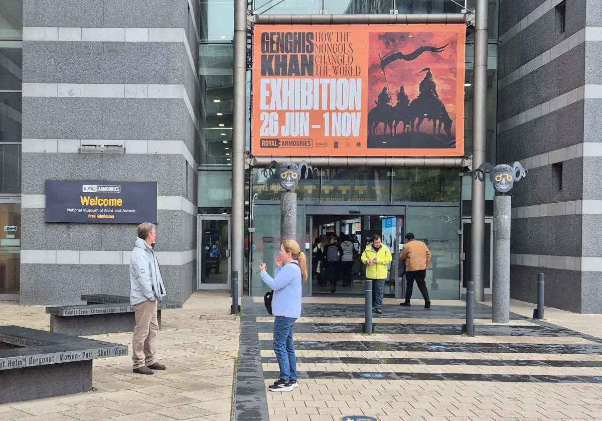 Outside of Royal Armouries Museum. People are walking outside, and an exhibition sign for Genghis Khan is being advsertised