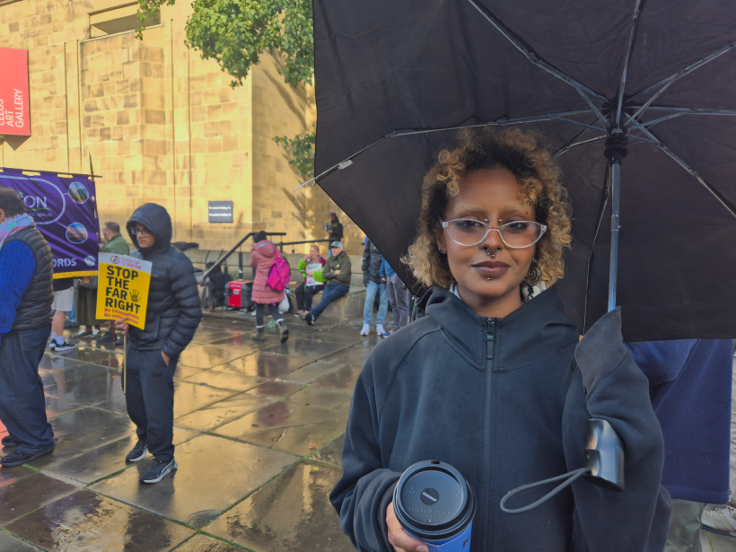 Eman Abdura hman Sayed holding a black umbrella and coffee cup