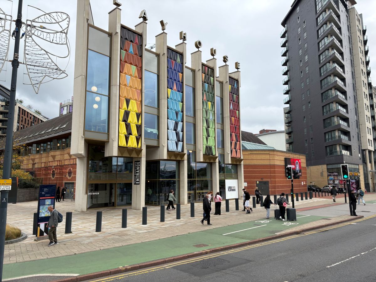 The front of a building, multiple colours including blue, yellow, green and red on the front of the building. 