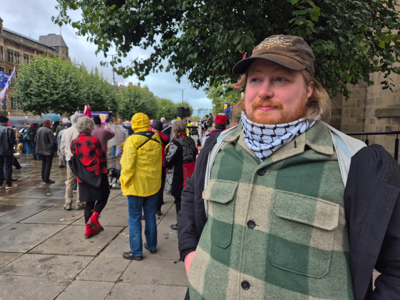 James Banning. He wears a black and white scarf and black jacket