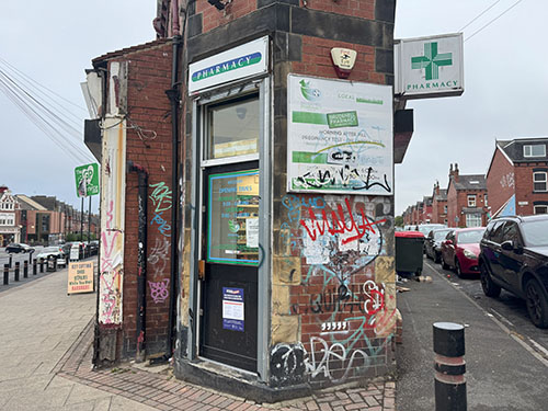 Image of a pharmacy, with signs and graffiti across the walls.